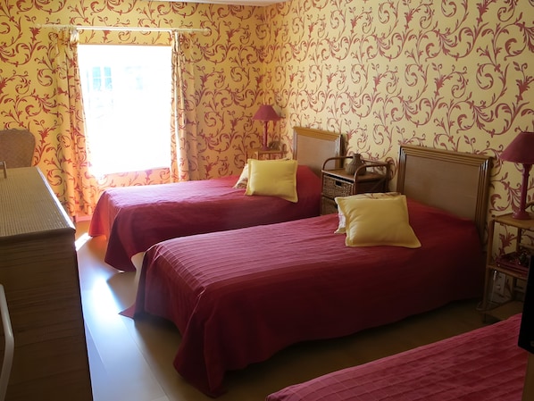 Una habitación con dos camas, un escritorio y una silla.