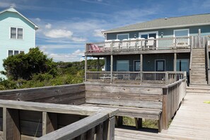 Un bâtiment à deux étages doté d’un balcon et d’une terrasse en bois à l’avant.