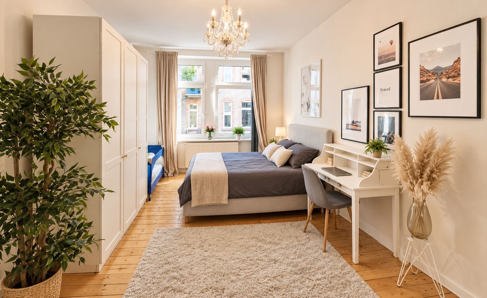 A bedroom with a bed, bedside table, desk, chair, and a large window.