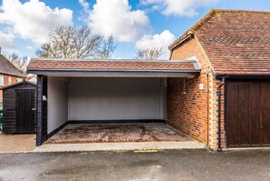 Eine Garage mit Ziegelwand, Metall-Dach und Betonboden.