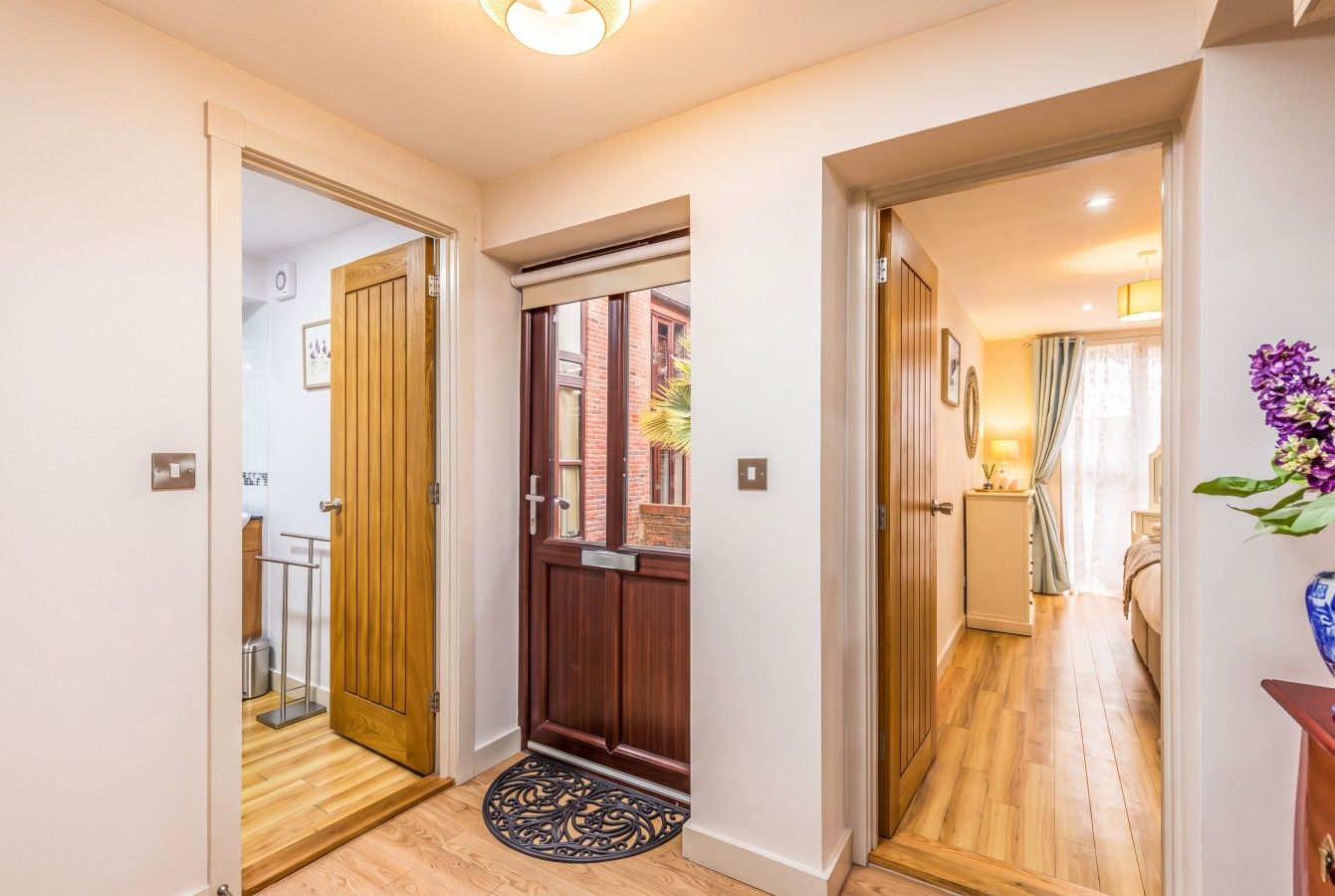 The entrance hall links the bedrooms and bathroom off a central door.