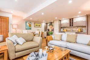 A modern living room with two sofas, a coffee table, and a kitchen area in the background. - Ground-Floor 2-Bed Apt · Free Parking · Walk to Fishbourne Roman Palace (Fishbourne)