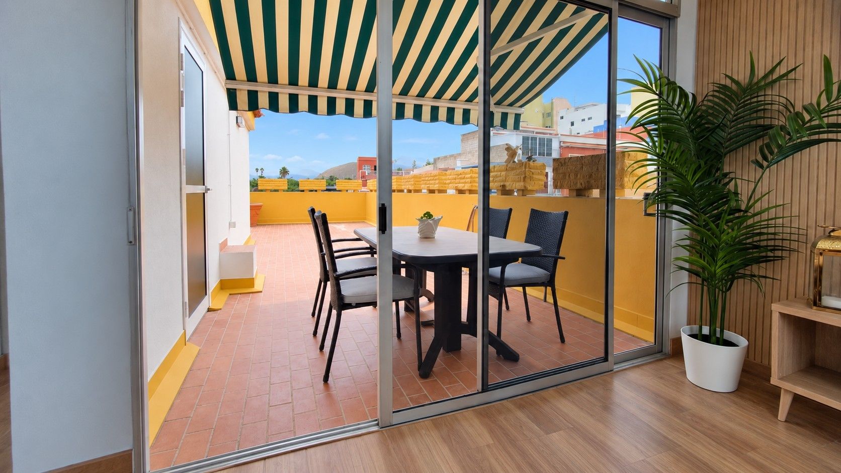 Una habitación con una puerta corrediza de vidrio que da a un patio exterior con una mesa y sillas.