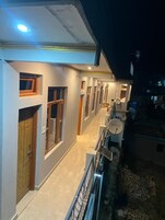 A corridor with doors and windows, a satellite dish, and a railing.