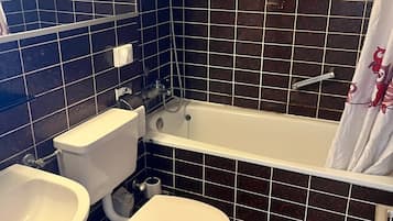 A bathroom with a toilet, sink, and bathtub.