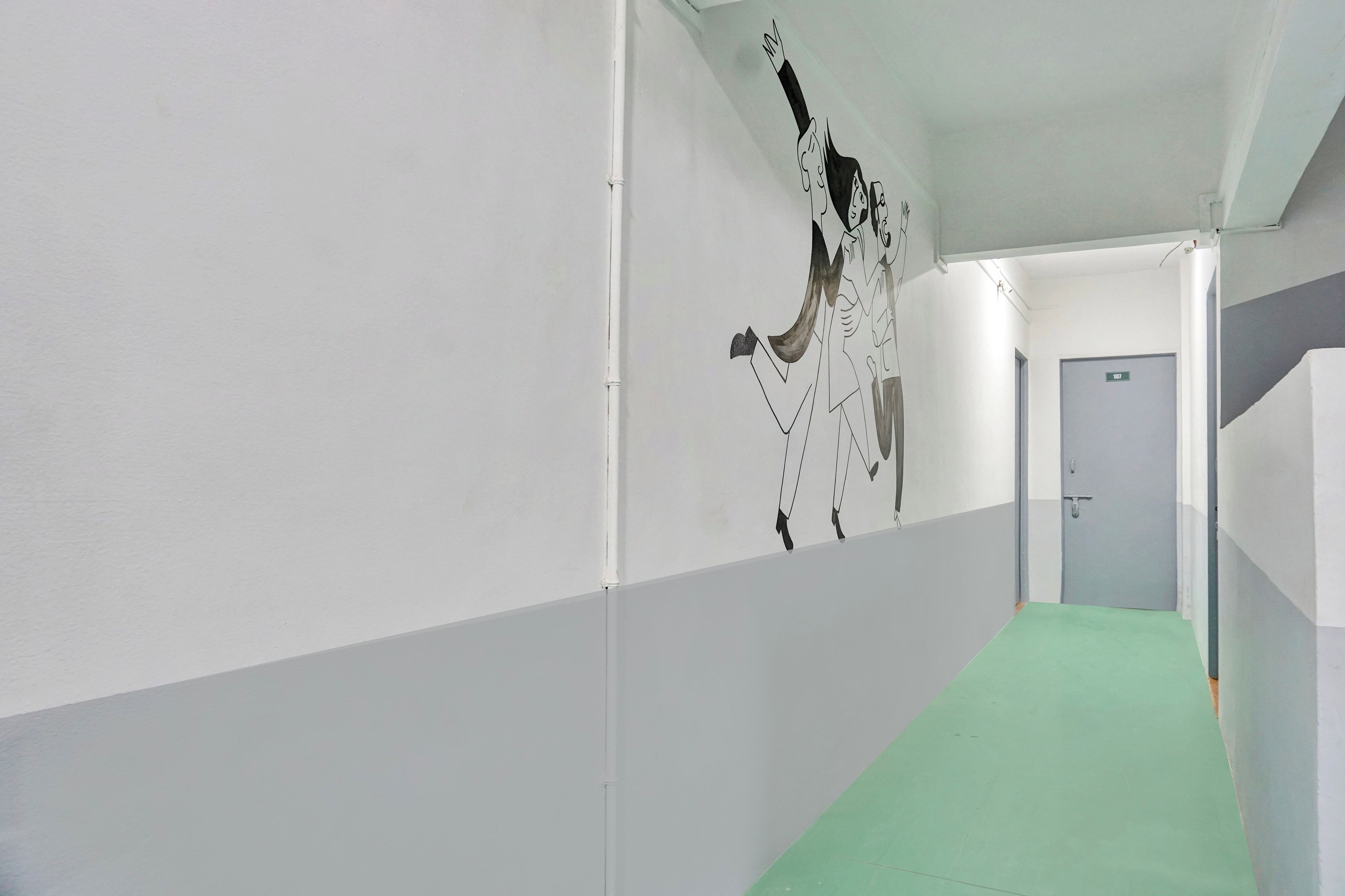 A corridor with a green carpet, white walls, and a door labeled '101'.