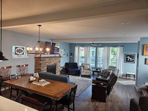 A spacious living area with a fireplace, dining table, and comfortable seating. - Stylish Ohio City Retreat Near W25, Gordon Square, Edgewater Beach & Restaurants (Cleveland)