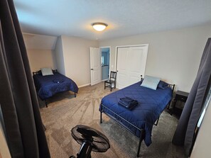 A room with two beds, a ceiling fan, and a door leading to another room. - Stylish Ohio City Retreat Near W25, Gordon Square, Edgewater Beach & Restaurants (Cleveland)