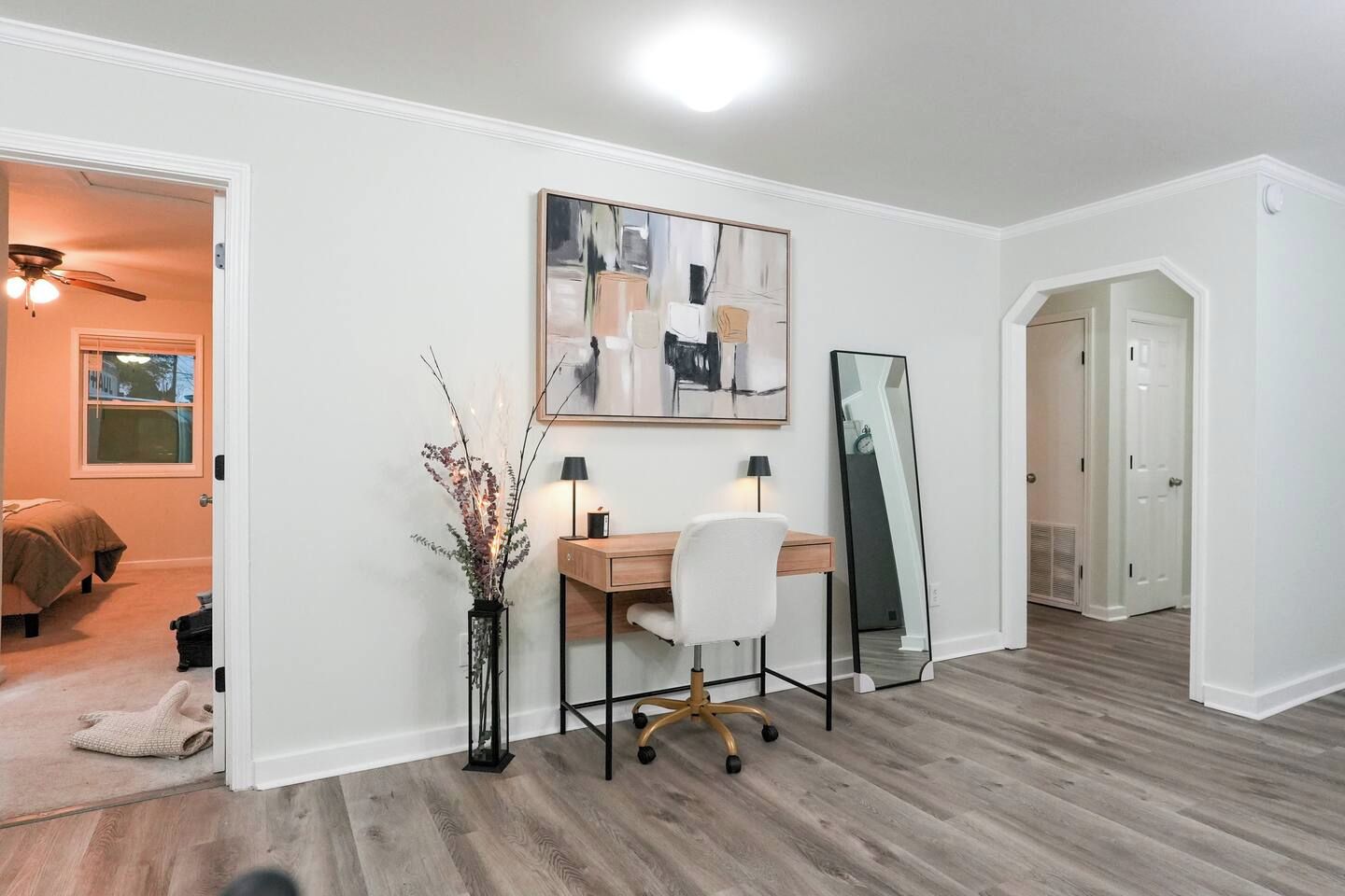 Une pièce comprenant un bureau, une chaise et un grand miroir.