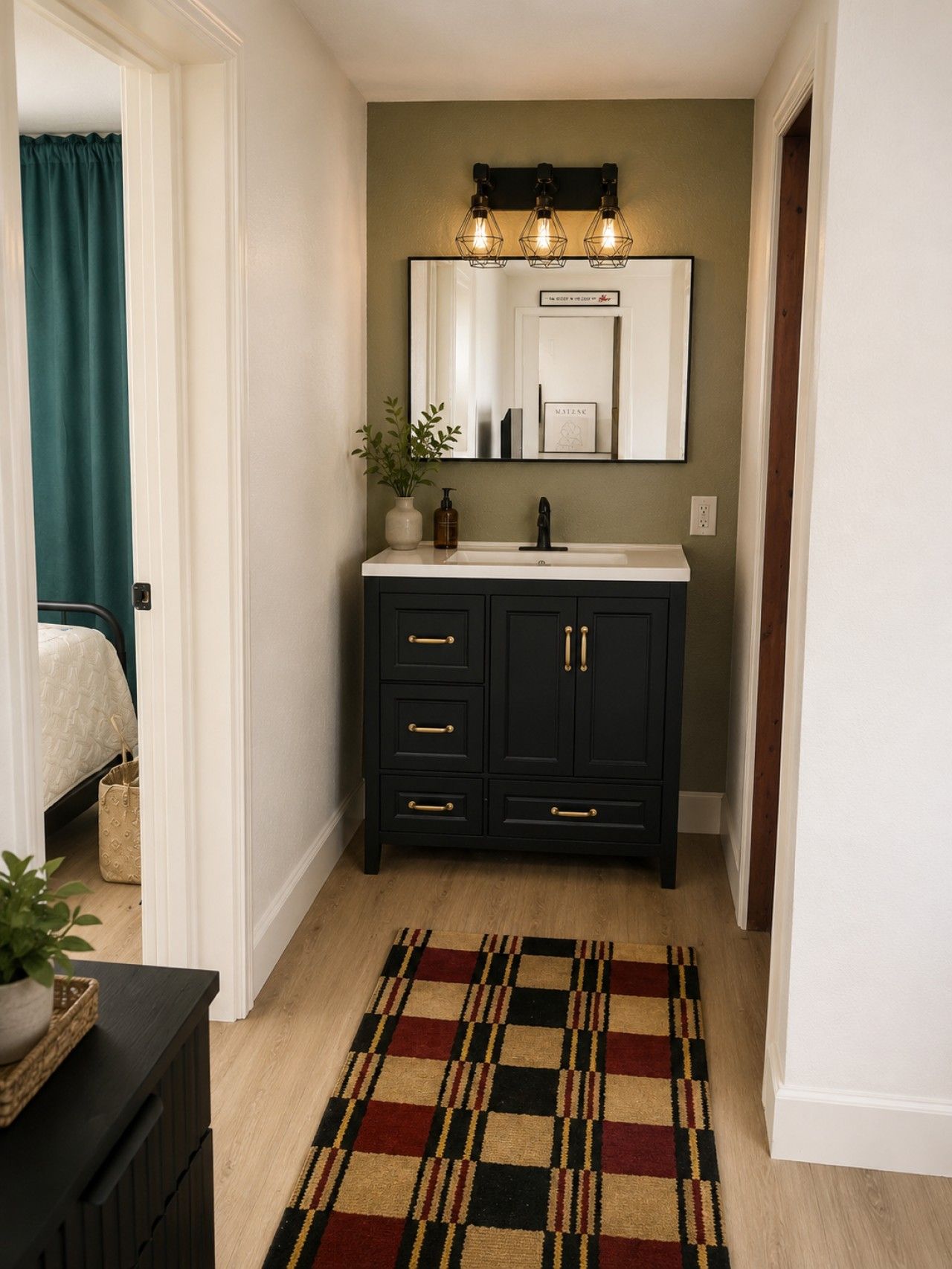 Un pasillo estrecho con un mueble de madera oscuro, un lavabo blanco y un espejo encima.