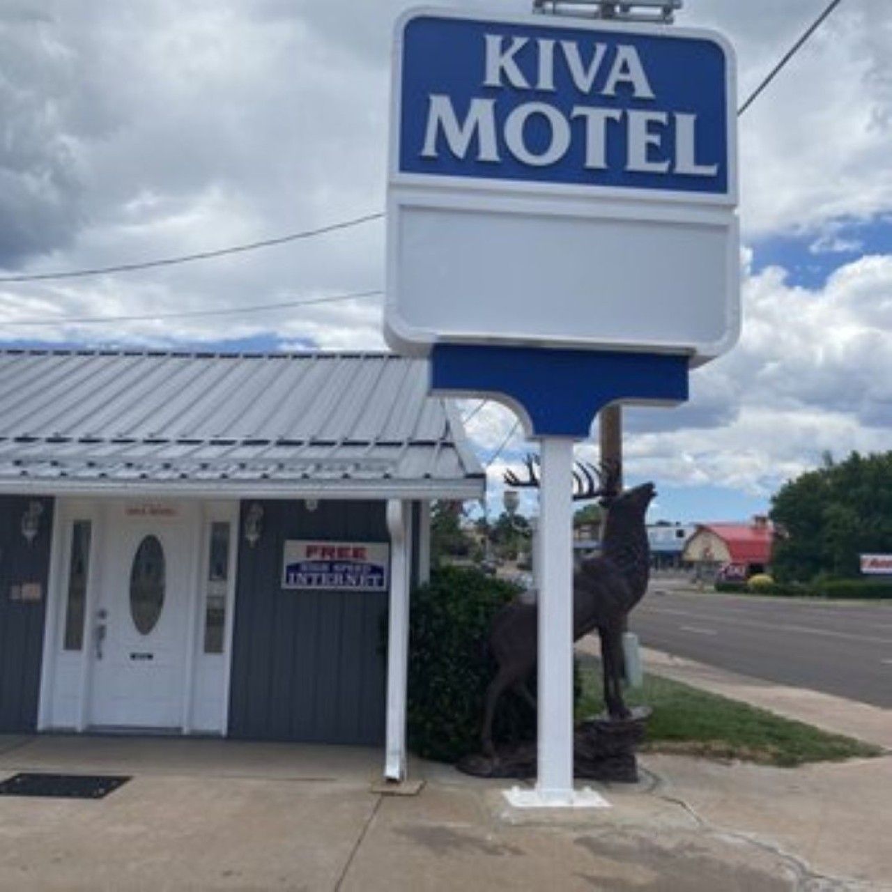 A motel sign with the name 'Kiva Motel' and a small building with a sign that reads 'FREE INTERNET'.