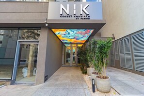 A building with a modern facade, a glass entrance, and a colorful mural above the entrance. - Prime Bela Vista - Av. Paulista - Sírio (São Paulo)