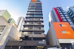 En byggnad med flera våningar, där ett stort, väl synligt "NIK"-skylt sitter på markplan, vilket tyder på att det kan vara ett hotell eller en kommersiell fastighet.