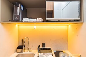 A compact hotel room with a kitchenette, a sink, and a small countertop. - Prime Bela Vista - Av. Paulista - Sírio (São Paulo)
