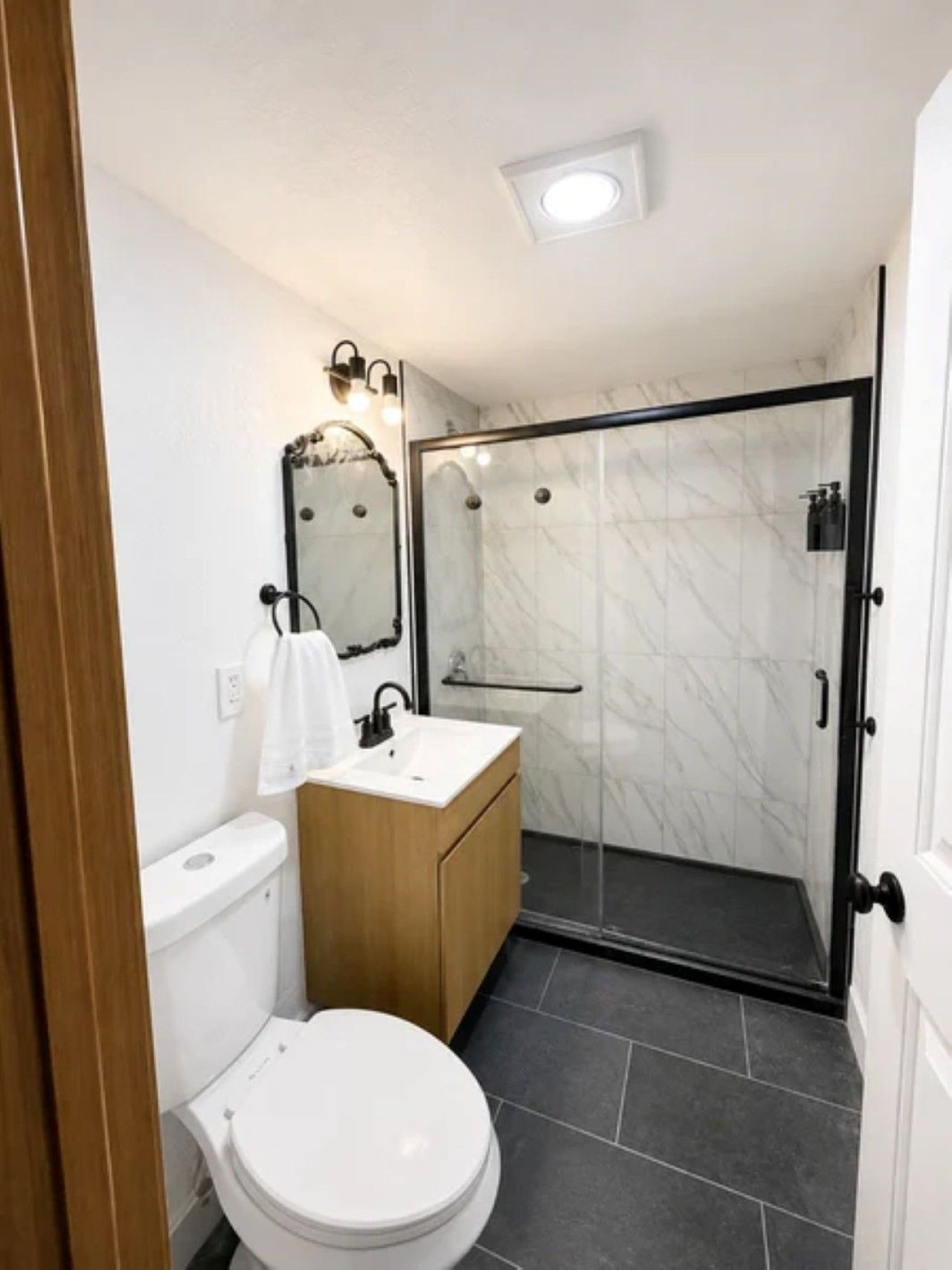 A modern bathroom with a toilet, sink, and shower.