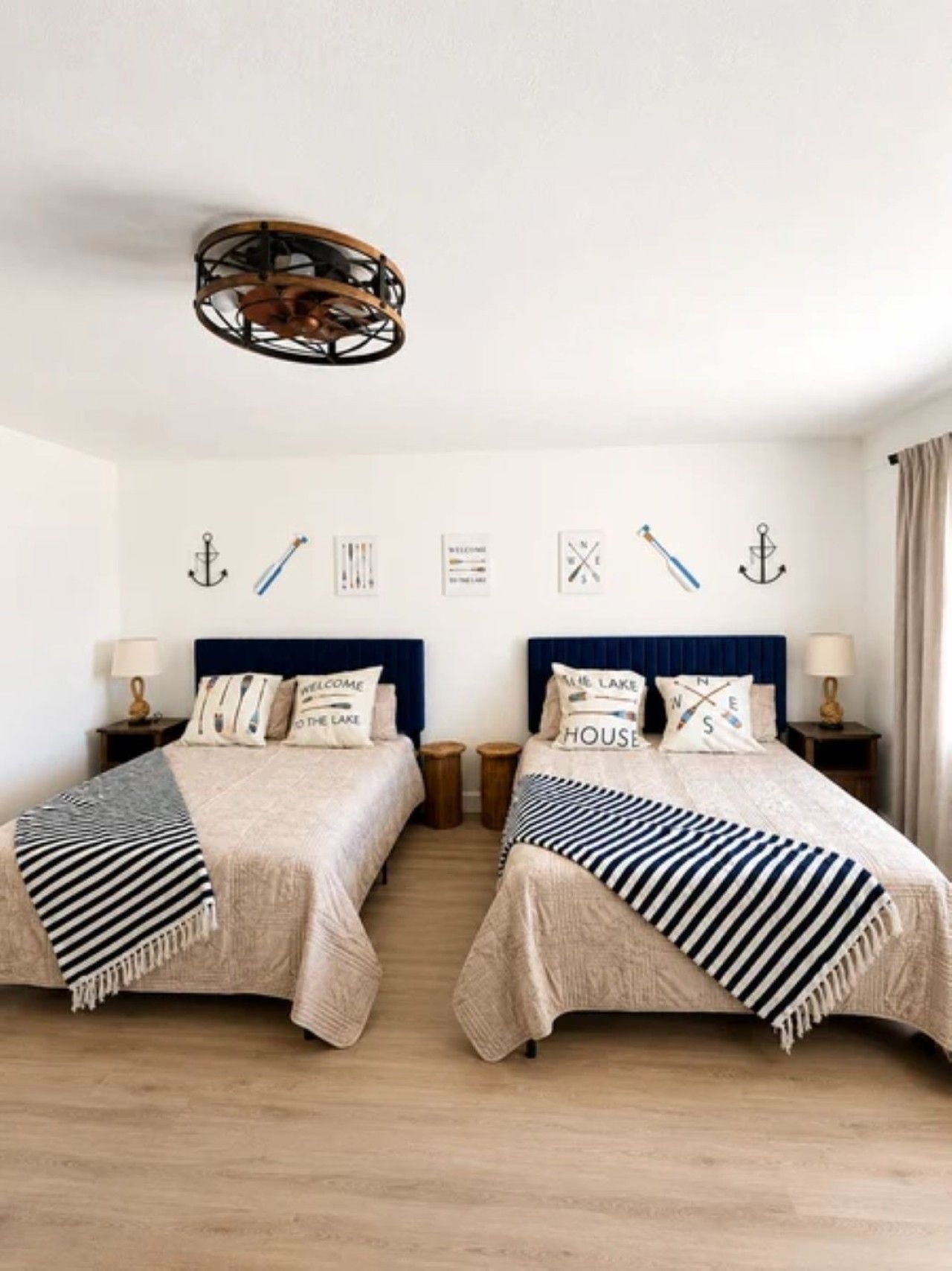 A double bed room with a nautical theme, including anchor wall decor and striped bedding.