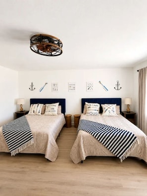 A double bed room with a nautical theme, including anchor wall decor and striped bedding. - Escape to the cool mountain air and peaceful beauty of Arizona’s White Mountains (Show Low)