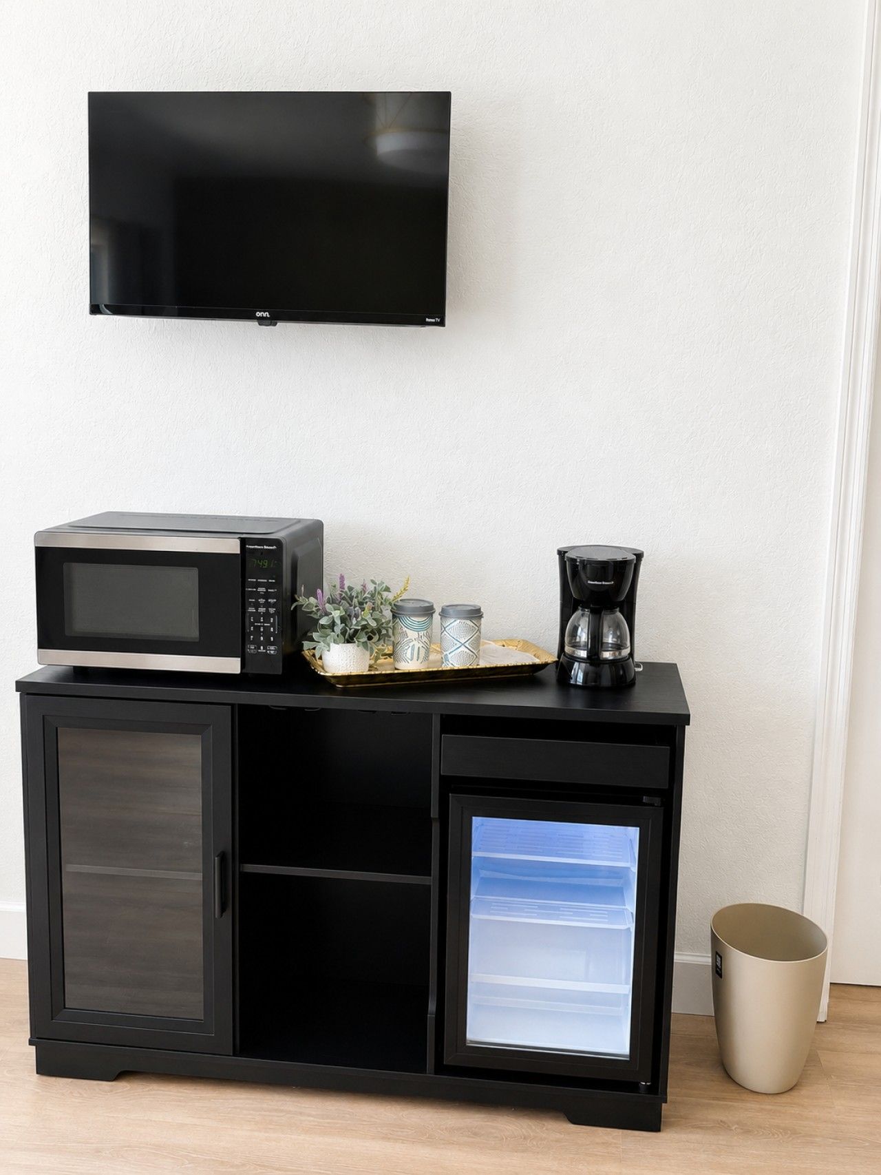 A kitchenette with a microwave, coffee maker, and a small refrigerator.