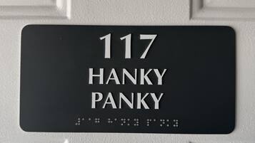 Un cartel con el número 117 y el nombre 'HANKY PANKY' en una puerta blanca.