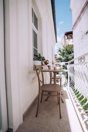 A narrow balcony with a table and chairs, white walls, and a white railing. - Casa Versus Ohrid (ohrid)