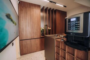 A modern kitchen with wooden cabinets, a built-in water dispenser, and a wall-mounted coffee machine. - Casa Versus Ohrid (Ohrid)