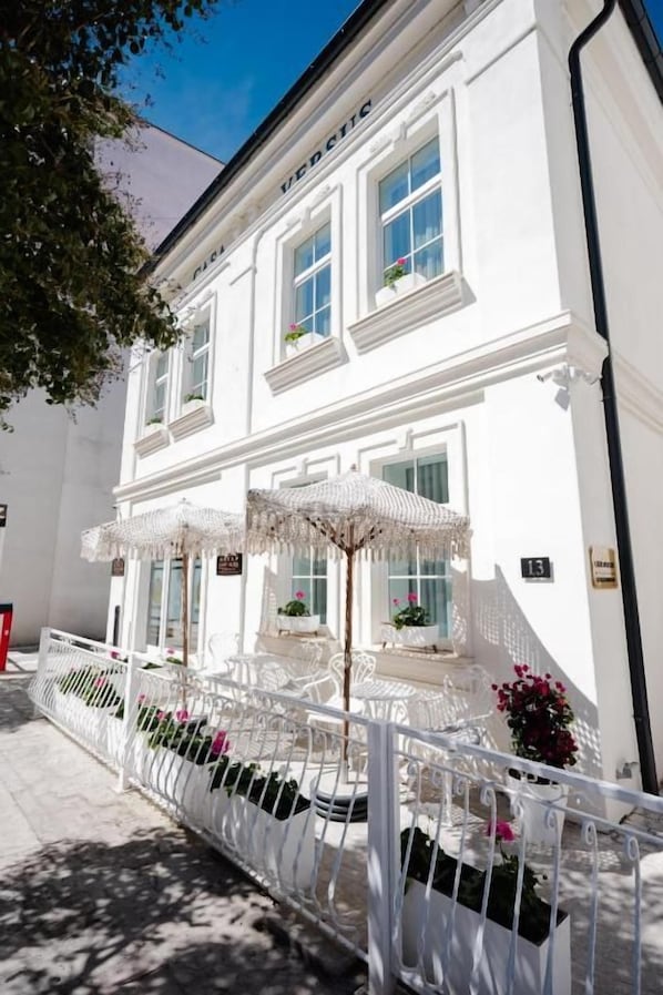A white building with a balcony, potted plants, and a sign with the number 13. - Casa Versus Ohrid (Ohrid)