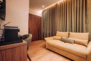 A modern living room with a sofa, a coffee table, and a television on a wooden stand. - Casa Versus Ohrid (Ohrid)