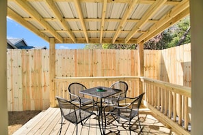 A wooden deck with a table and chairs, surrounded by a wooden fence.