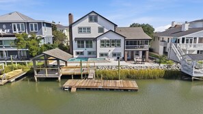 A waterfront property with a large house, dock, and a swimming pool. - Marsh Bend: 8  BR, 5  BA House in Pawleys Island, Sleeps 21 (Pawleys Island)