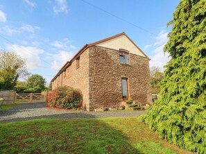 A stone building with a gabled roof, a front door, and a small window. - Greig House Farm (Abergavenny)