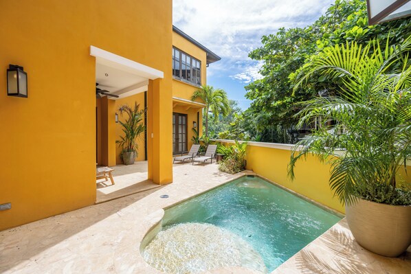 A yellow building with a swimming pool, outdoor seating, and potted plants. - Las Catalinas Luxury Villa Pool & Beach Club Access (Las Catalinas)