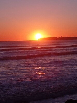 A sunset over the ocean with waves. - COSY CUTE COUNTRYSIDE CABIN (CLARE)