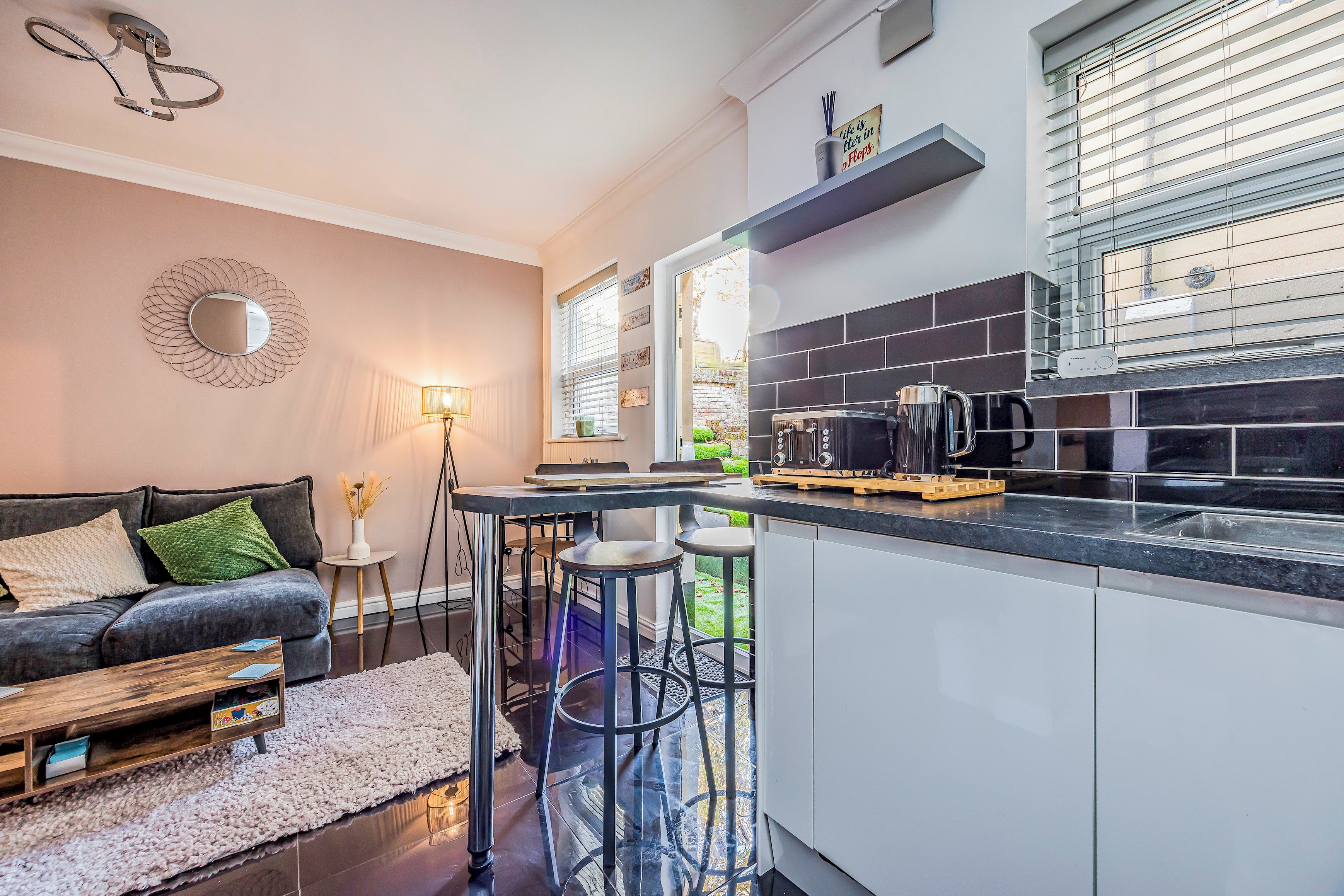 Une cuisine moderne avec un coin bar, une table à manger et un canapé dans l’espace salon.