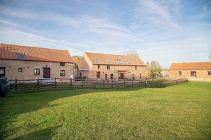 A brick building with multiple windows and a wooden fence. - The Threshing Barn - Pass the Keys (Blankney Fen)