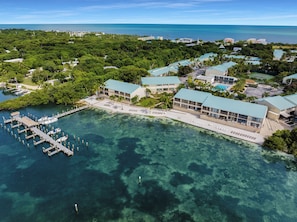 An aerial view of a resort with a marina, clear waters, and lush greenery. - Islamorada Townhouse - Sunsets, Beach & Sparkling Pool! (Islamorada)