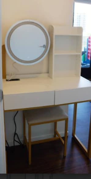 Ein Zimmer mit einem Holztisch, einem runden Spiegel und einer kleinen Bank.