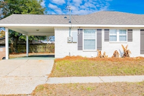 A single-story house with a covered porch, a front yard with a small garden, and a satellite dish. - Sweet Cedar (Mobile)