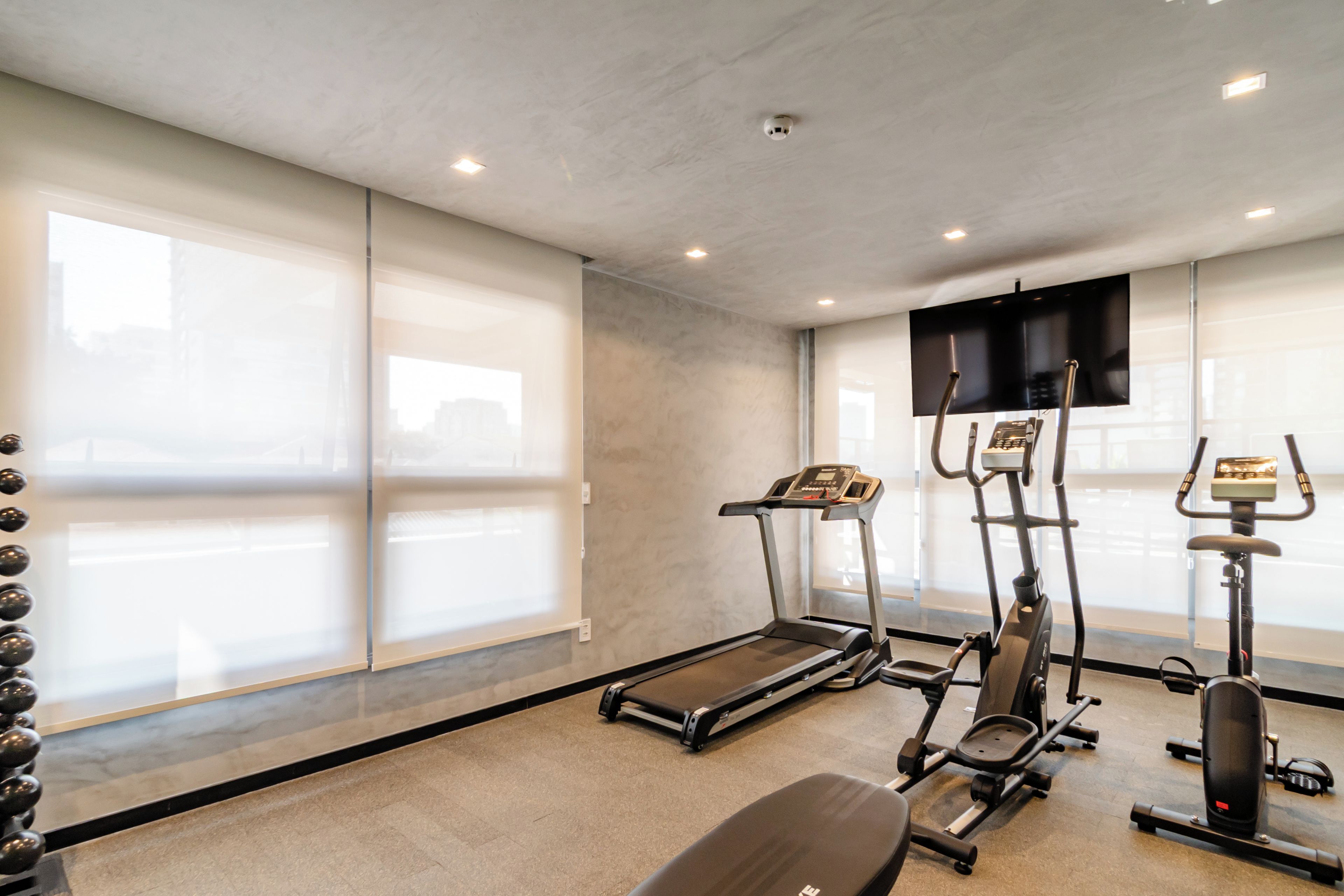 A gym with treadmills, elliptical machines, and a stationary bike.