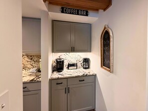 A kitchen with a coffee bar sign, a chalkboard with writing, and a marble countertop. - Cozy 1BR Condo Across from Sugar Mountain Resort | Fireplace | Sleeps 4 (Banner Elk)