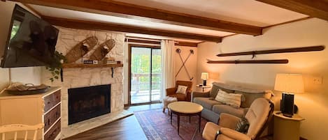A cozy living room with a fireplace, a television, a sofa, and a coffee table.