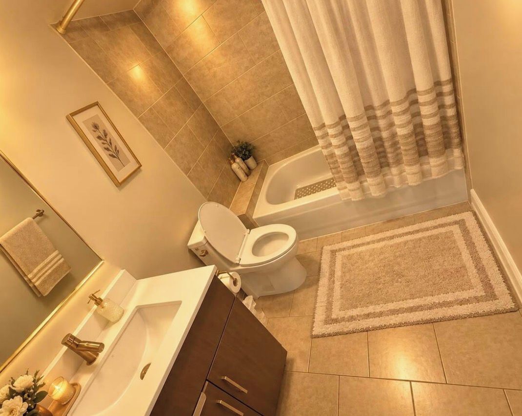 Une salle de bain équipée d’une baignoire, de toilettes, d’un lavabo et d’un rideau de douche.