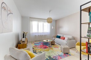 Un saló modern amb un sofà, una taula de centre i una catifes colorida.