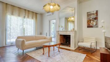 A spacious living room with a fireplace, a sofa, a chair, and a coffee table.