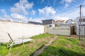 A residential area with a white wall, a metal gate, and a pathway leading to a house. - Clin d’Œil sur la Mer - 300m de la Plage (Cucq)