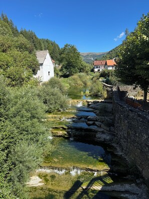 A river flowing through a rural landscape with stone bridges and houses. - Your Perfect Stay Near Pamplona (Ansoáin)