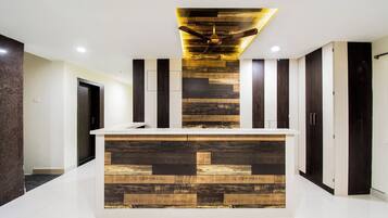 Una cocina moderna con una isla central, paneles de madera en la pared y un lámpara en el techo.
