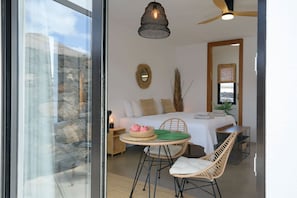 A bedroom with a bed, a bedside table, a chair, a table, and a ceiling fan. - Fantastic 3-bedroom house with heated pool in Tías perfect for your getaway (Tías)
