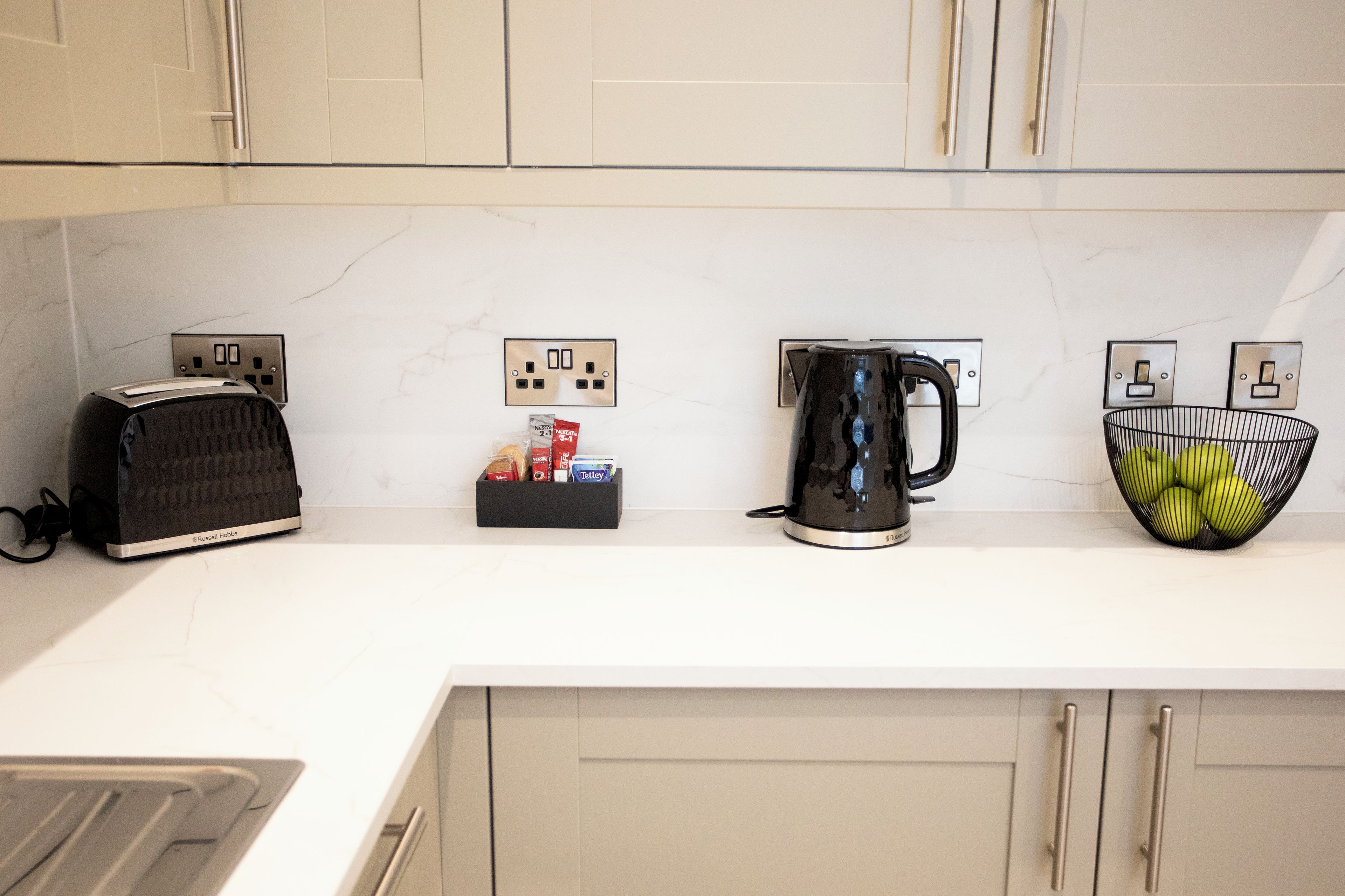 Eine Küchenarbeitsplatte mit einem Toaster, einer Kaffeemaschine und einer Obstschale.