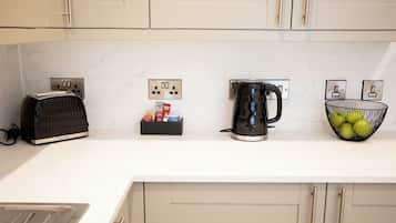 Eine Küchenarbeitsplatte mit einem Toaster, einer Kaffeemaschine und einer Obstschale.