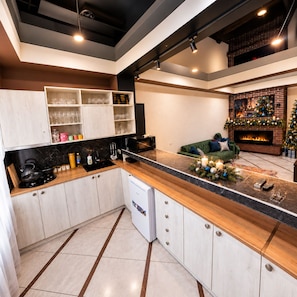 A modern kitchen with a central island, built-in cabinets, and a fireplace.